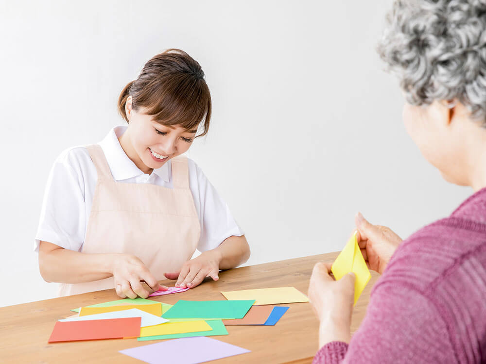 介護士と折り紙を折る